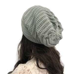 Close-up back view of a light grey chunky knit beanie on a model with stacked texture