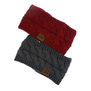 Close-up of cable knit textures on burgundy and grey winter headbands with leather labels