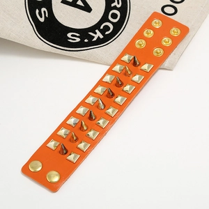 Punk orange leather bracelet with three rows of gold spiked rivets and metal studs