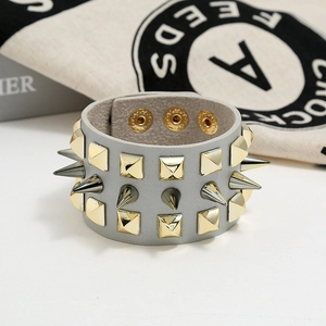 Detail of punk wide leather bracelet with triple rows of gold studs and silver spikes