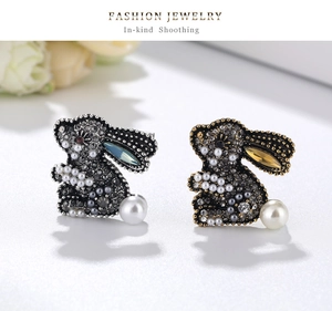 Macro detail of crystal rabbit brooches with inlaid pearls and sparkling rhinestones
