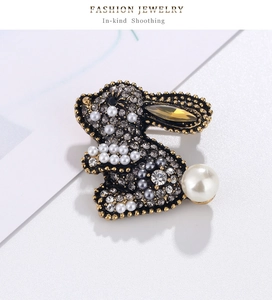 Macro detail of crystal encrusted rabbit brooch with yellow gemstone and white pearl