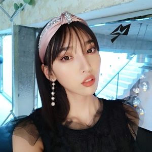 Close-up of pink satin knotted headband with crystal stripes and pearl tassel earrings