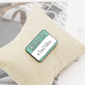 Detail of mint green and white rectangular brooch pin on a linen pillow cushion