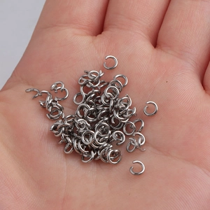 Macro shot of silver stainless steel open jump rings on palm for jewelry making