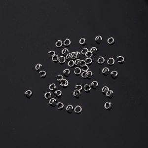 Macro shot of silver stainless steel open rings for jewelry making on black background