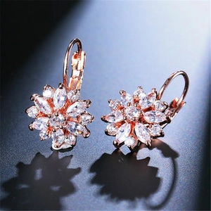 Detail of rose gold flower drop earrings with marquise-cut white cubic zirconia