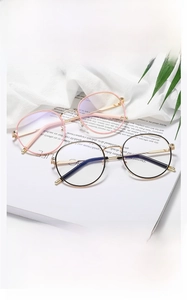 Detail view of round metal glasses frame featuring pink and black minimalist design
