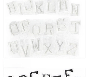 Close-up of black and white embroidered alphabet patches with twill texture
