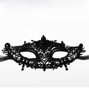 Detailed close-up of a black lace masquerade mask with intricate heart and leaf embroidery
