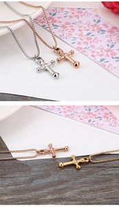 Detailed close-up of titanium steel cross pendants in silver, rose gold, and gold finishes