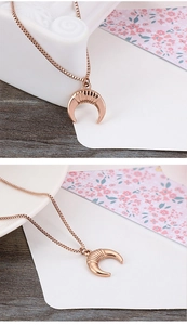 Detail of rose gold moon pendant with vertical texture on a delicate box chain