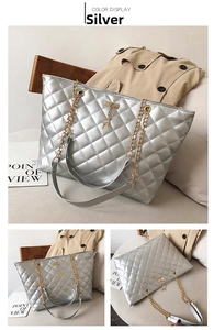 Detail of silver quilted tote bag with gold chain strap and deer charm ornament
