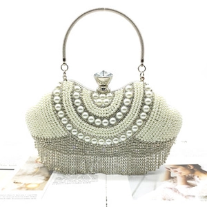 Macro shot of pearl wavy patterns with silver tassels and large crystal clasp on clutch