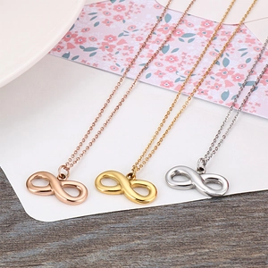 Three infinity symbol necklaces in gold, rose gold, and silver on a floral card