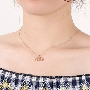 Rose gold infinity symbol necklace in stainless steel worn by a model on collarbone