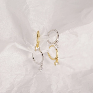 Close-up of gold and silver S925 sterling silver hoop earrings with zircon pendants