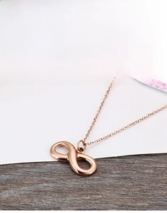 Detail of rose gold infinity pendant on a fine chain showing polished finish and craftsmanship