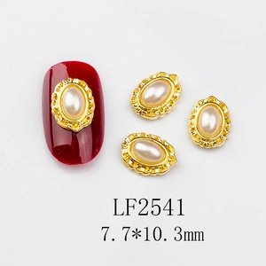 Detailed view of vintage oval nail art charms with faux pearl and gold embossed edges