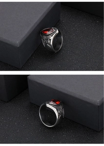 Macro shot of vintage stainless steel ring featuring red gemstone and ornate engraving