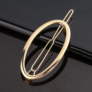 Macro d'une pince à cheveux minimaliste en alliage doré au design géométrique ovale