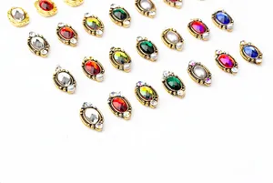 Detailed view of vintage oval alloy nail charms with colorful faux gemstones and pearls