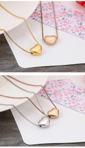 Detailansicht von Herzanhänger-Halsketten in Gold, Roségold und Silber auf einem Teller