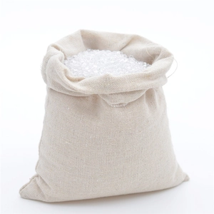 Vue macro d'un sac en lin beige à tissage grossier rempli de granules blancs nets