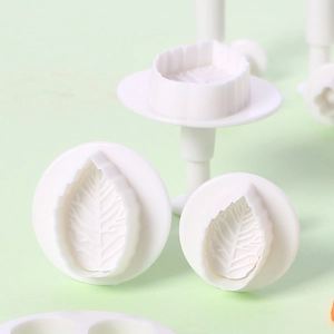 Macro detail of three white plastic leaf plunger cutters showing realistic vein textures