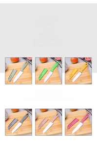 Detail view of colorful stainless steel paring knives with protective sheath covers