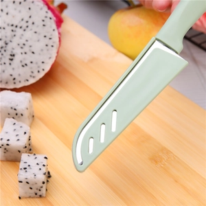 Green stainless steel fruit knife with protective sheath on a wooden cutting board