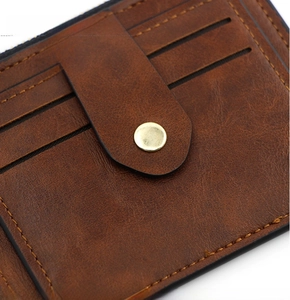 Detail of brown vintage leather wallet showing card slots and golden snap button
