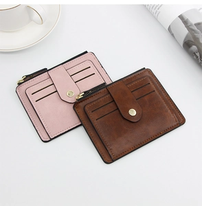 Detail of pink and brown leather card wallets showing card slots and metal snap closure