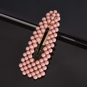 Close-up of golden BB hair clip featuring matte pink bead embellishments for women
