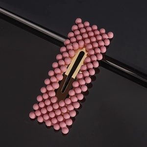 Detailed close-up of a pink pearl hair clip with matte beads and gold metal BB clip