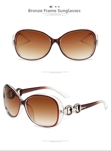 Detail view of large frame oversized sunglasses with gradient brown lenses and metal hinges
