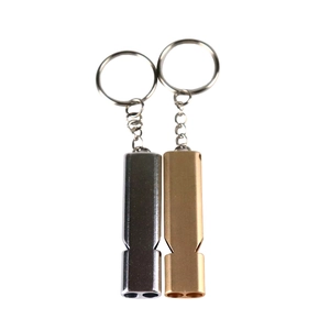 Close-up of double-tube aluminum survival whistles in silver and bronze with keychains