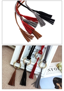 Detail of woven fringe tassels with golden rings in brown, black, red and grey shades