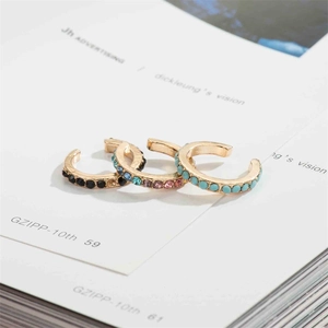 Three-piece set of gold ear cuffs with black gems, colorful crystals, and turquoise beads