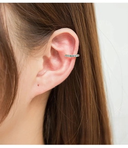 Close-up of U-shaped ear bone clip with colorful rhinestones on a golden base