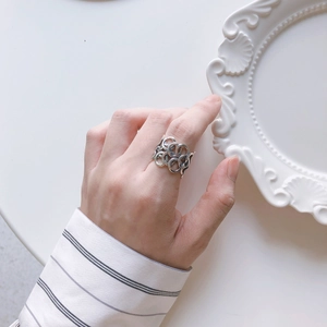 Minimalist 925 sterling silver multi-layered hollow ring on hand with elegant white background