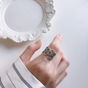 Close-up of vintage 925 silver hollow interlaced ring worn on hand for elegant styling