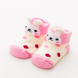 Close-up of baby socks with pink polka dots and cute 3D cartoon animal ear design