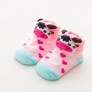 Close-up of pink cotton baby socks with cute cow pattern and lace bow detail