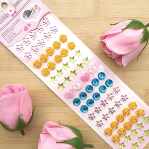 Colorful dimensional crystal stickers featuring hearts and stars on a wooden background