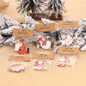 Décorations de Noël en bois coloré avec renne et Père Noël sur branche de pin