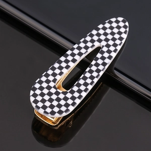 Macro shot of checkered pattern acrylic hair clip with a vintage gold metal base