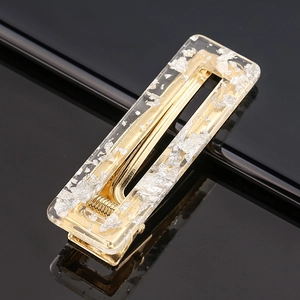 Macro detail of rectangle acetate hair clip with silver foil flakes and golden metal base