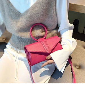 Dettaglio borsa a mano rosa fucsia con manico rotondo e tracolla rimovibile