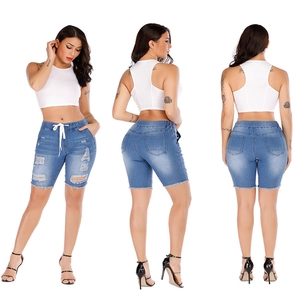 Three-way view of white ribbed tank top and blue distressed denim shorts with elastic waist